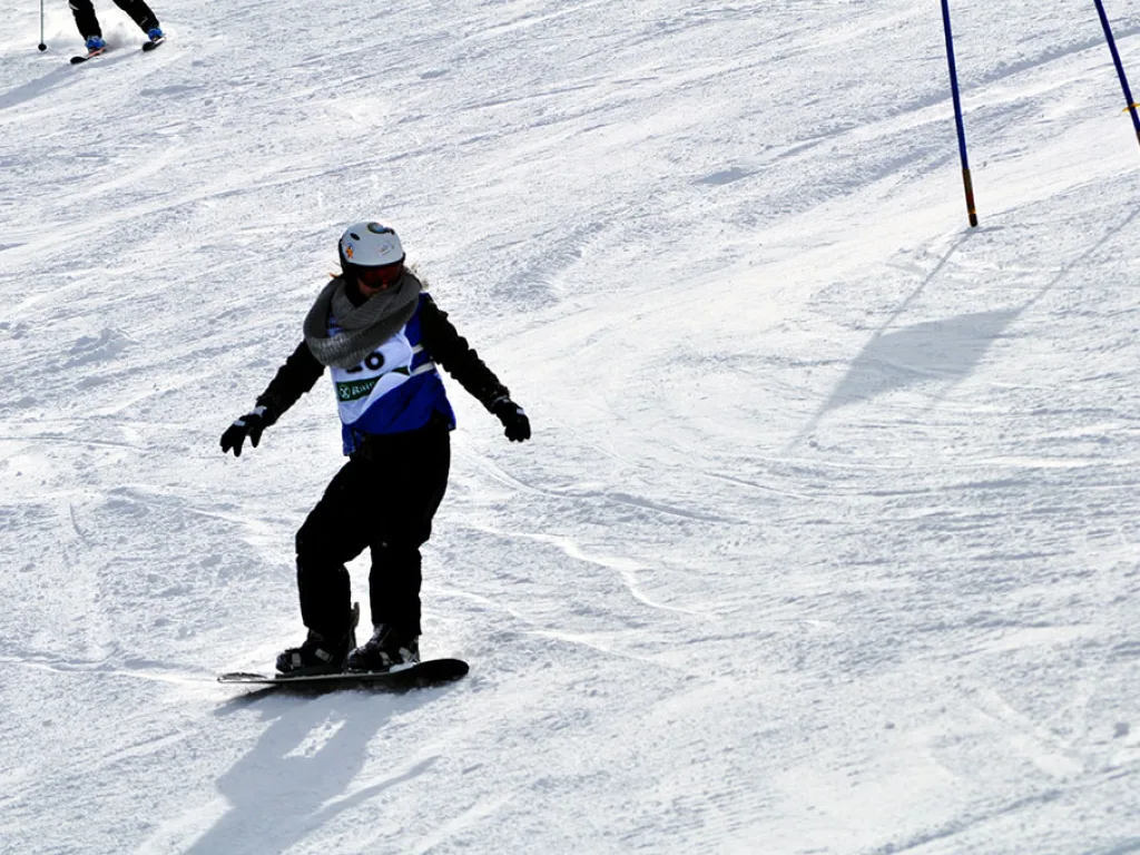 Snowboarderin mit Startnummer 20 auf der Piste.